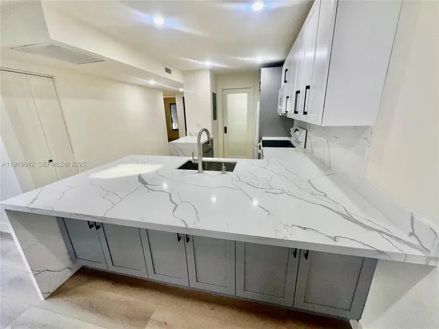 a kitchen with kitchen island a sink stainless steel appliances and cabinets