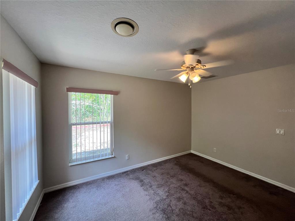 1995 East Newhaven Street Inverness, FL 34453 - Photo 31 of 48 an empty room with a chandelier fan and windows
