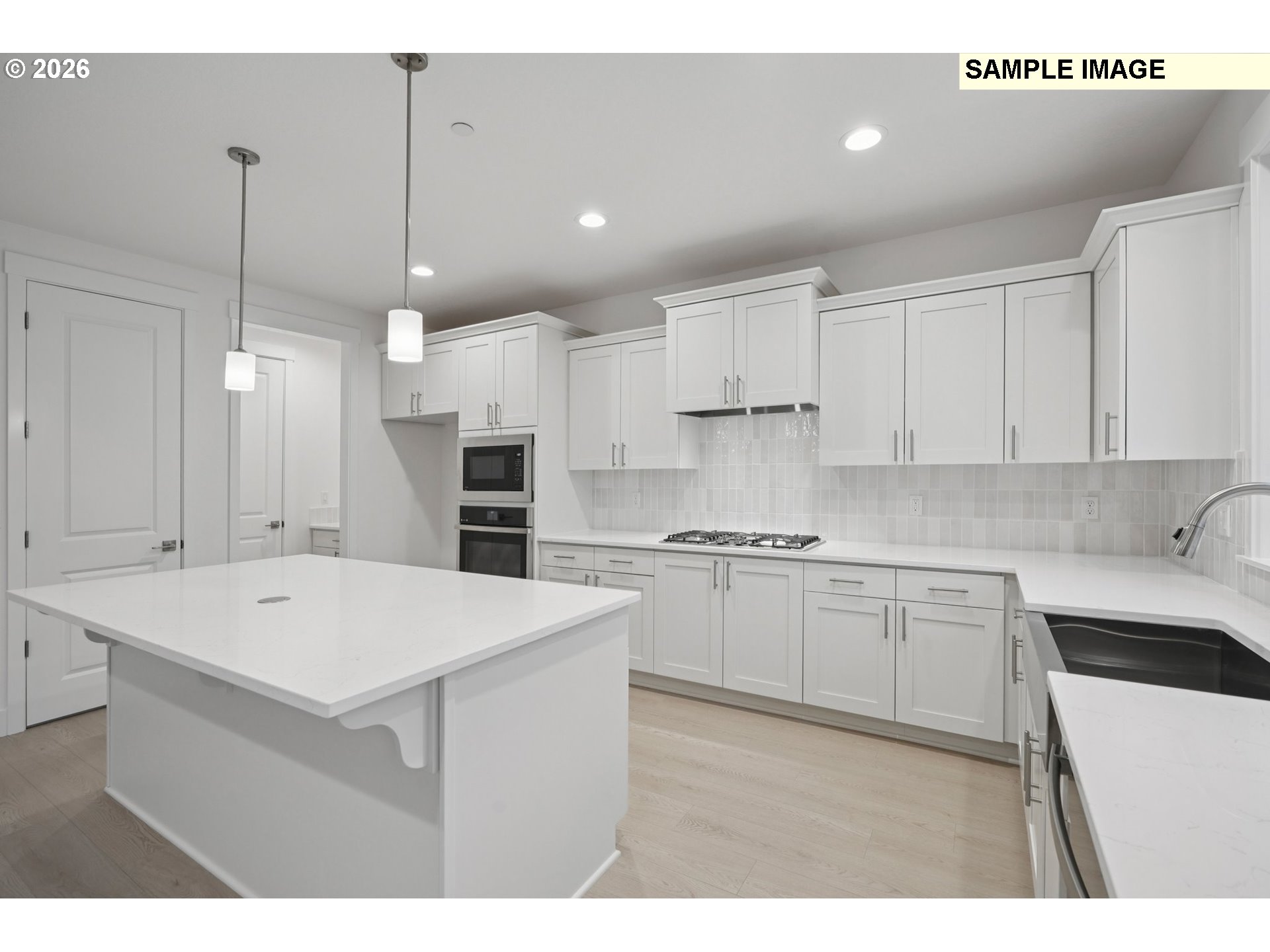 9302 North Clover Street, Unit LOT 267 Camas, WA 98607 - Photo 9 of 33 a kitchen with kitchen island a sink a stove a refrigerator and white cabinets