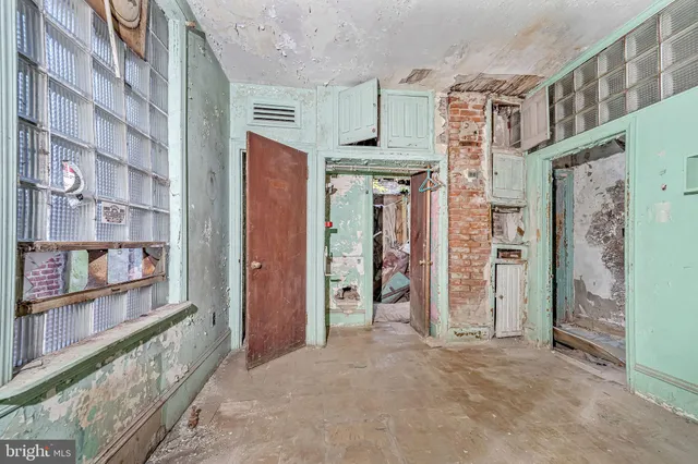 a view of a hallway with wooden door and stairs