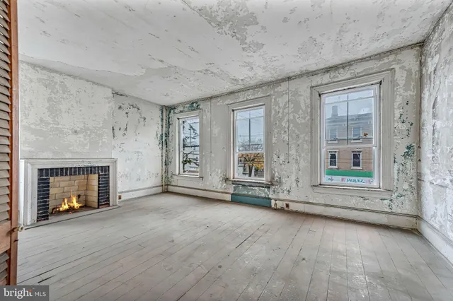 a room with a wooden floor and a fireplace