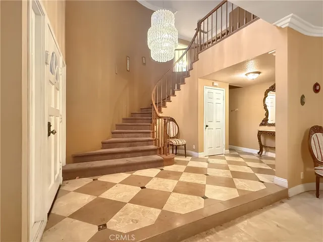 a view of a bedroom with wooden floor and a chandelier