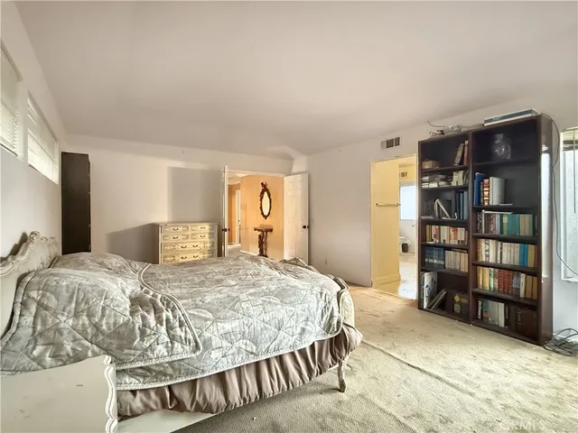 a bedroom with a large bed and a book shelf