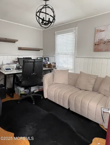 a living room with furniture a chandelier and a window