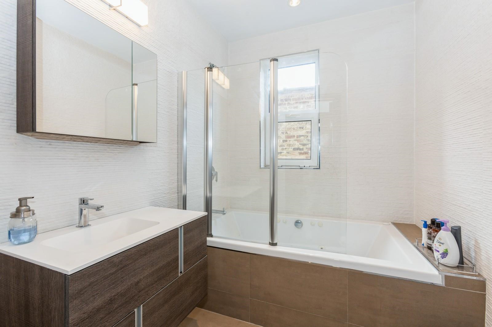 96 Columbia Terrace, Unit 1 Weehawken, NJ 07086 - Photo 21 of 40 a bathroom with a tub sink and a mirror