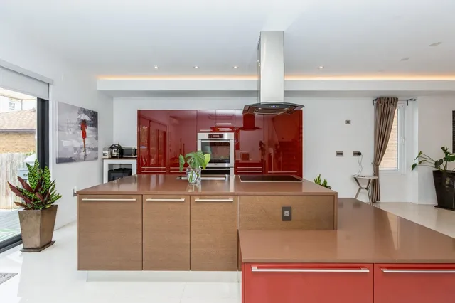 a living room with furniture a potted plant and kitchen view