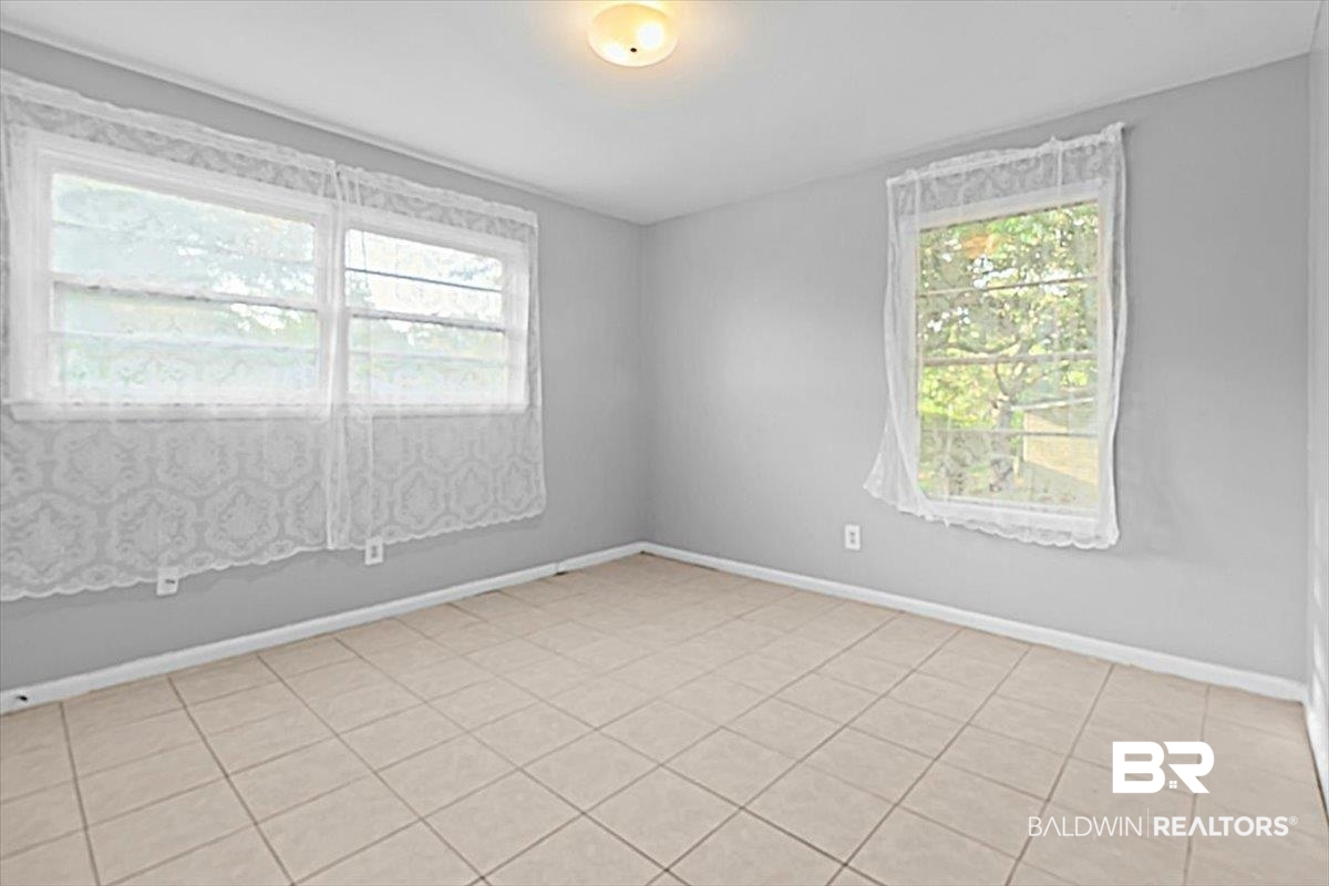4918 Quimby Drive Mobile, AL 36619 - Photo 16 of 38 Unfurnished room with plenty of natural light, baseboards, and light tile patterned floors