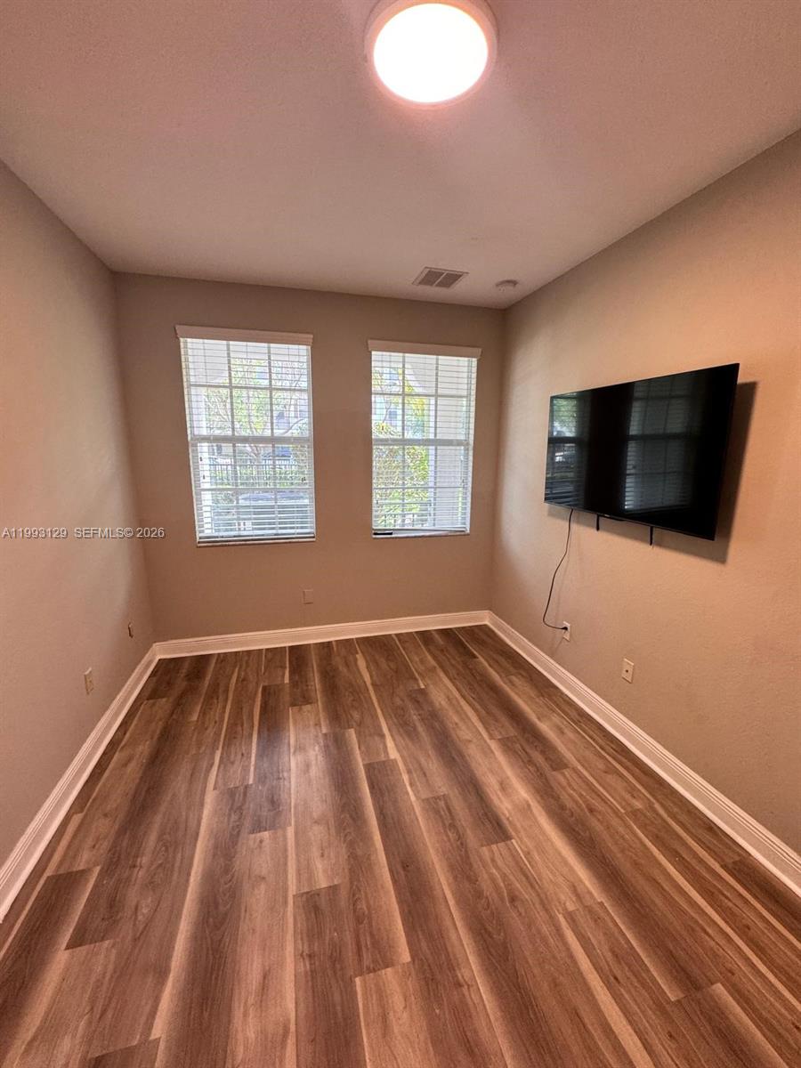 11980 Southwest 29th Street Miramar, FL 33025 - Photo 11 of 56 a view of a livingroom with wooden floor and flat screen tv