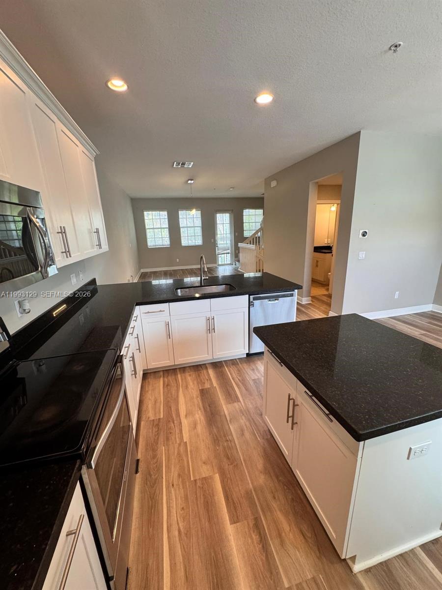 11980 Southwest 29th Street Miramar, FL 33025 - Photo 22 of 56 a large kitchen with granite countertop a sink dishwasher stove and cabinets