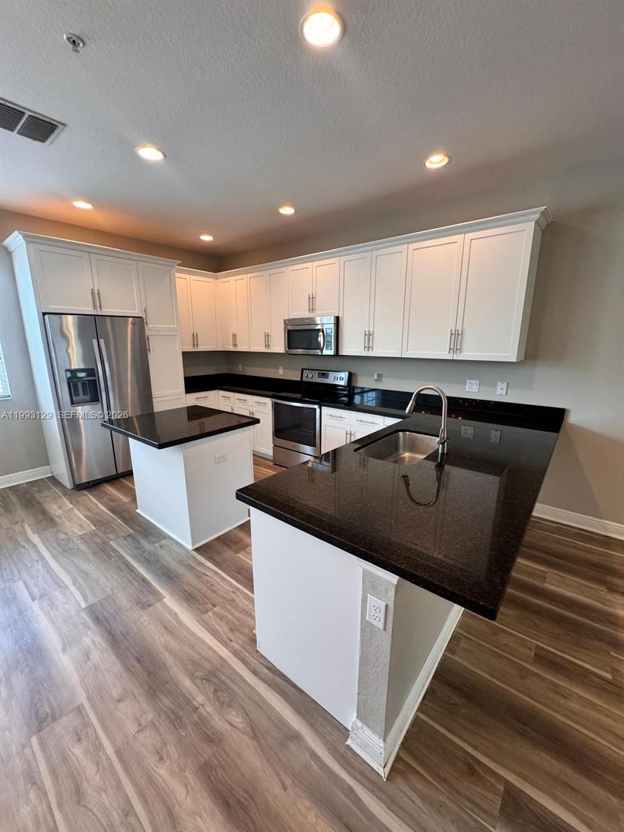 11980 Southwest 29th Street Miramar, FL 33025 - Photo 23 of 56 a kitchen with stainless steel appliances granite countertop a sink a stove and a refrigerator