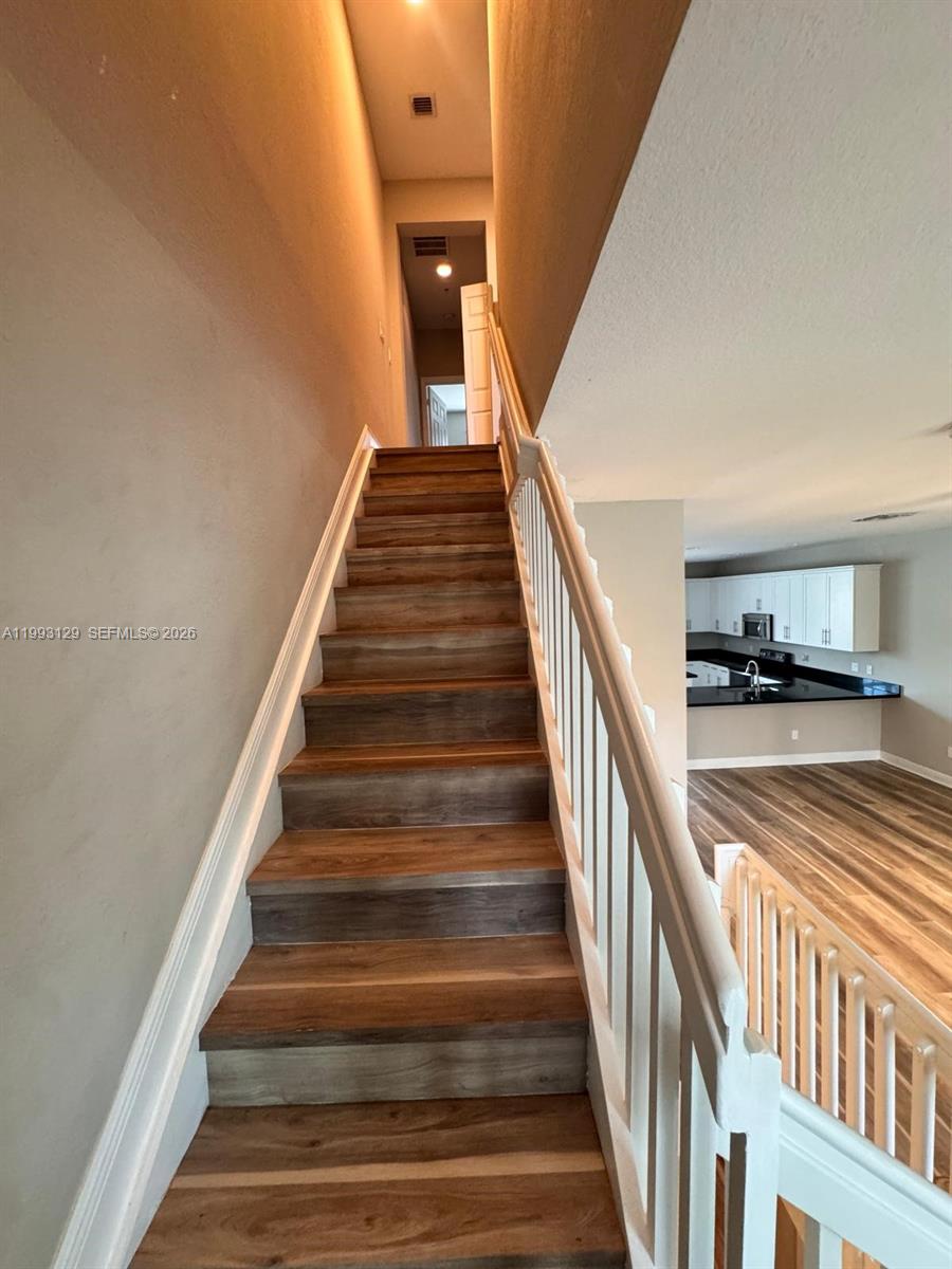 11980 Southwest 29th Street Miramar, FL 33025 - Photo 31 of 56 a view of staircase with lots of frames on wall and a view of entryway