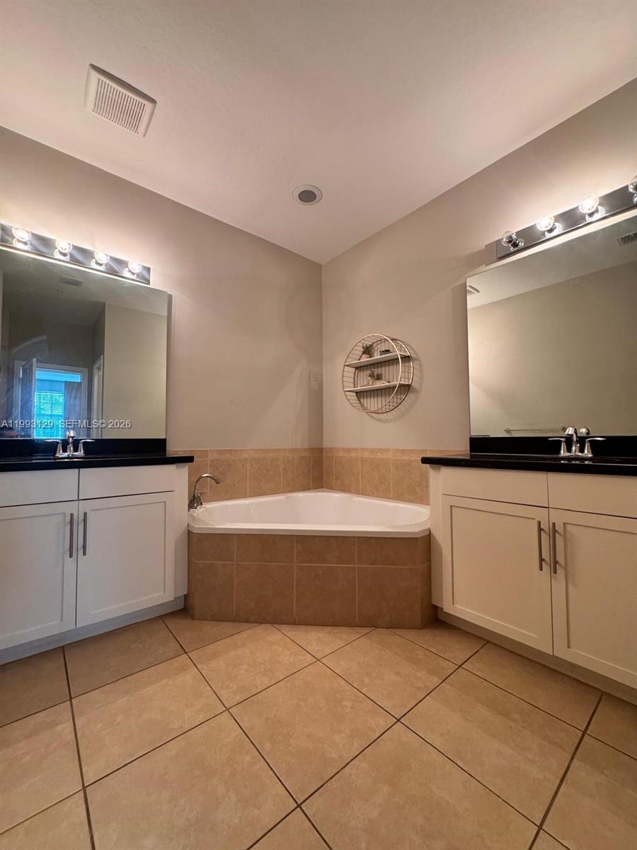 11980 Southwest 29th Street Miramar, FL 33025 - Photo 40 of 56 a spacious bathroom with a tub a sink and a mirror