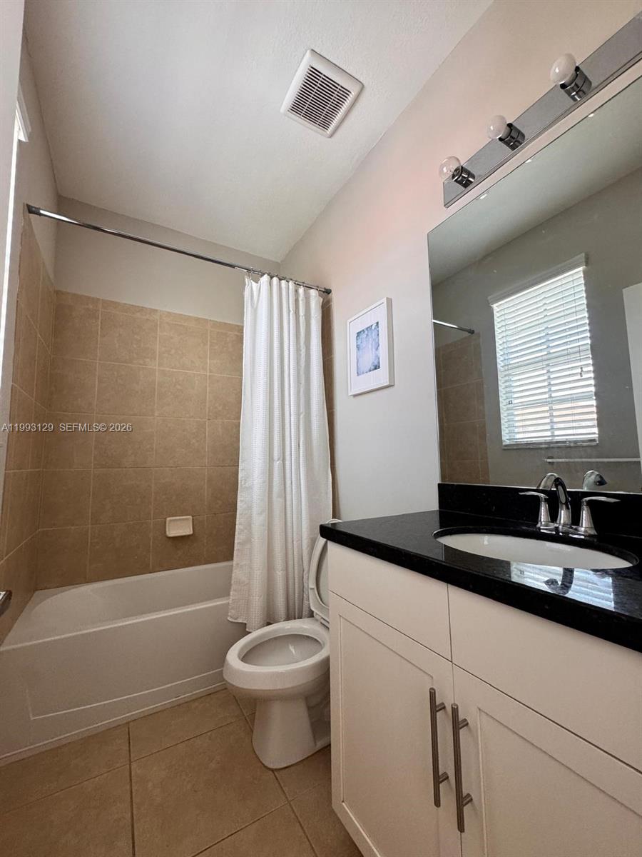 11980 Southwest 29th Street Miramar, FL 33025 - Photo 53 of 56 a bathroom with a granite countertop sink a toilet a mirror and shower