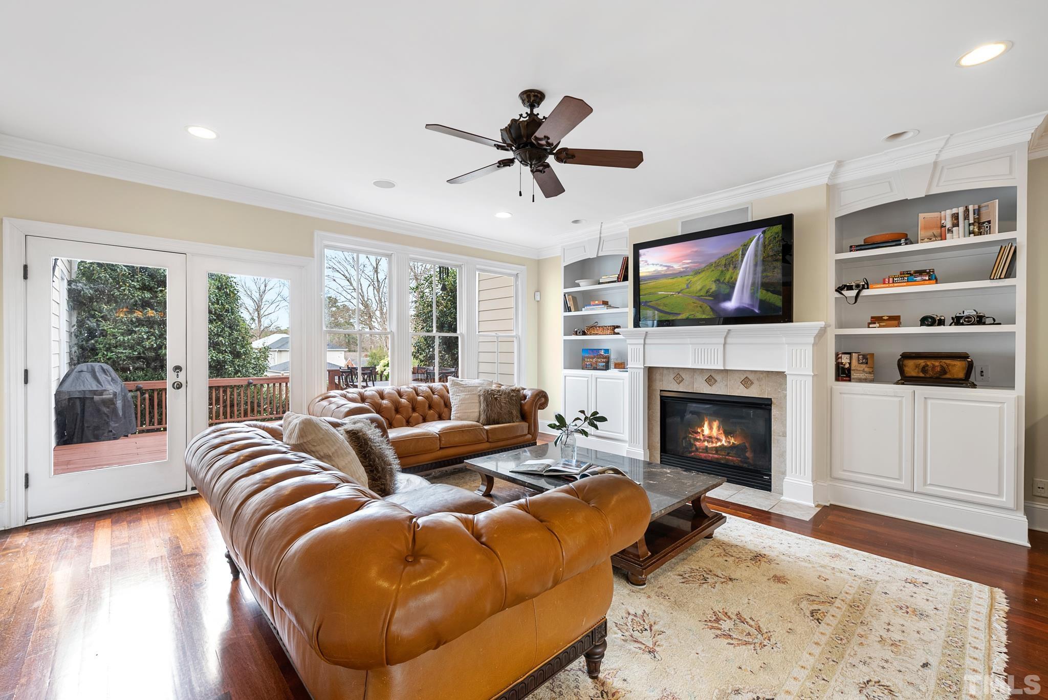 3044 Farrior Road Raleigh, NC 27607 - Photo 11 of 64 a living room with furniture a flat screen tv and a fireplace