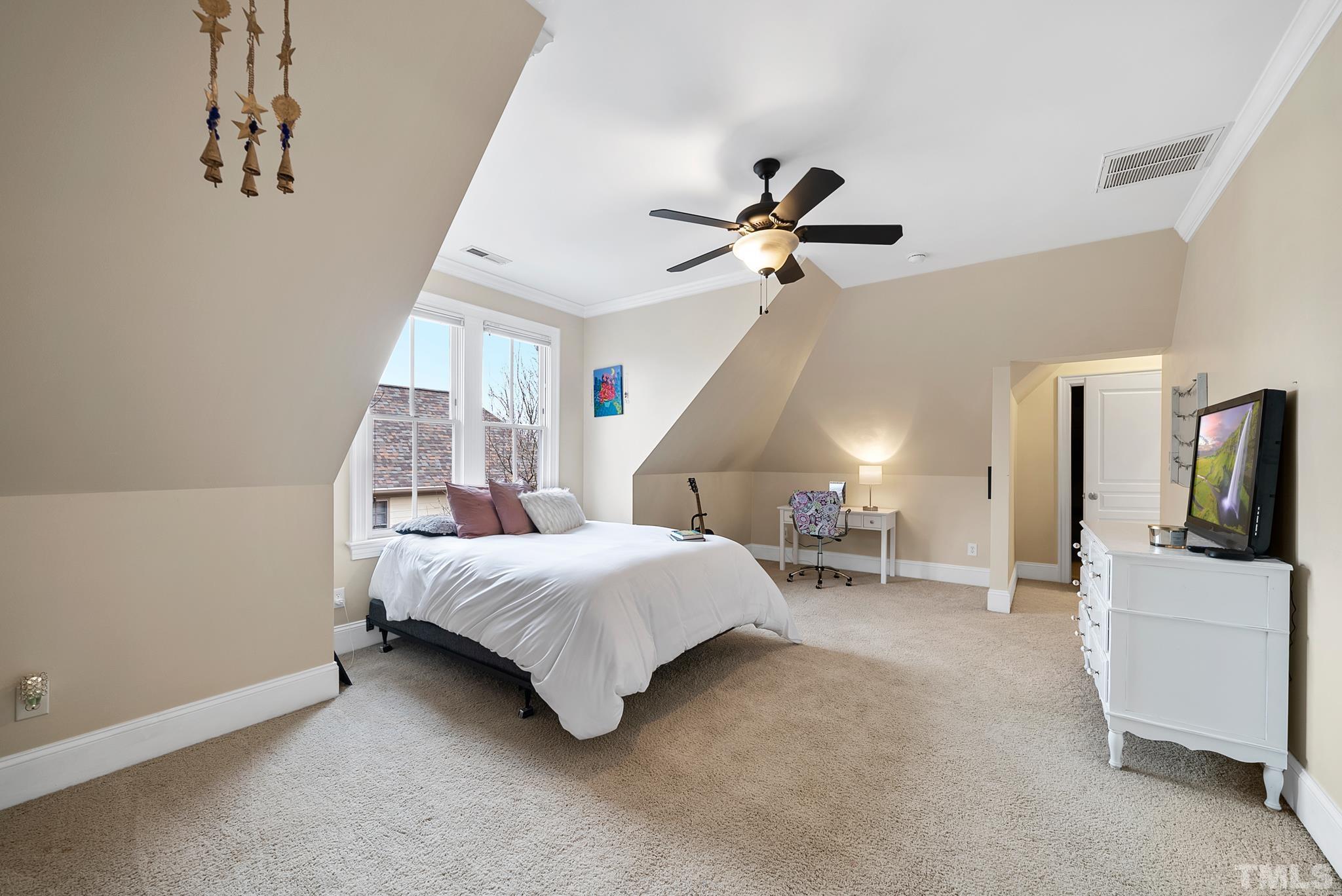 3044 Farrior Road Raleigh, NC 27607 - Photo 29 of 64 a bedroom with a bed a flat screen tv and a ceiling fan