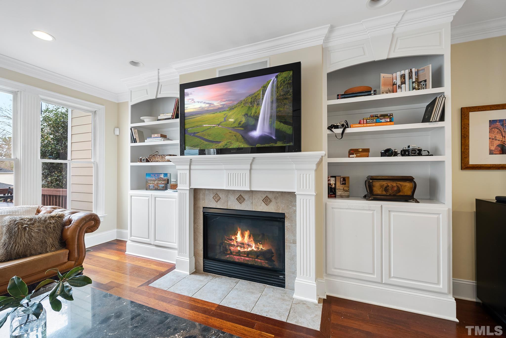 3044 Farrior Road Raleigh, NC 27607 - Photo 9 of 64 a living room with furniture a flat screen tv and a fireplace