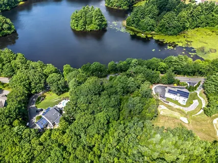 an aerial view of a house with a yard and lake view