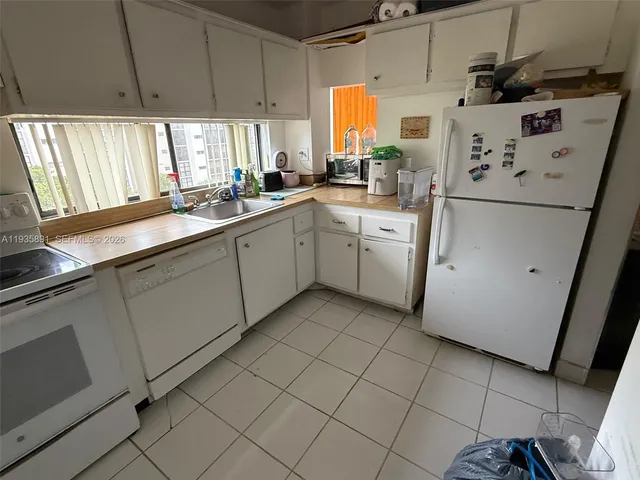 a kitchen with granite countertop a sink stainless steel appliances and cabinets