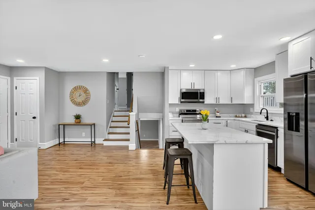 a kitchen with stainless steel appliances granite countertop a refrigerator stove microwave and cabinets