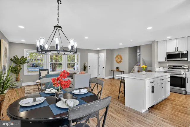 a view of a dining room with furniture a chandelier and wooden floor