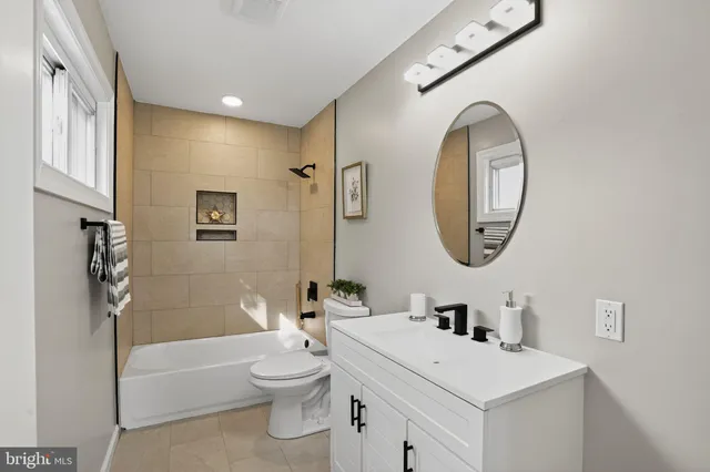 a bathroom with a toilet a sink a mirror and a bathtub