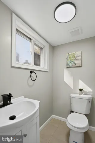 a bathroom with a toilet a sink and mirror