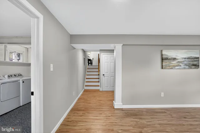 a view of a hallway with wooden floor and cabinet