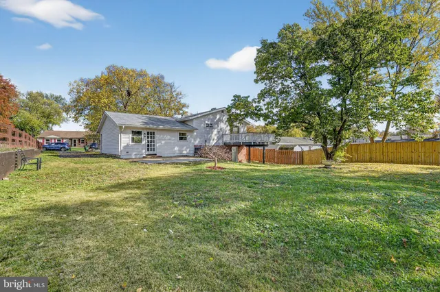a front view of a house with garden and trees