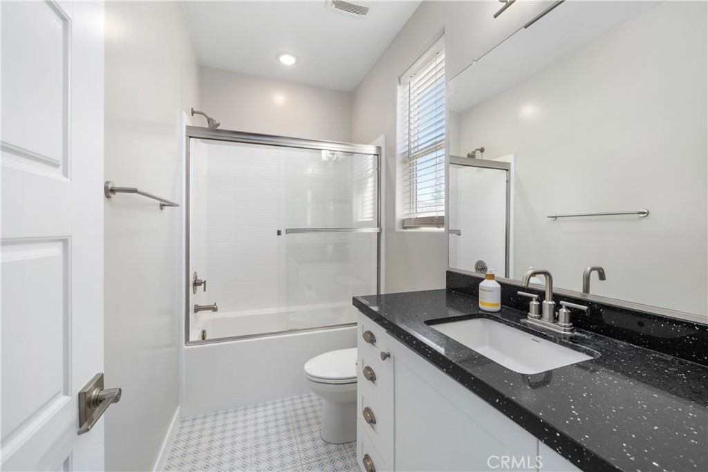 905 Madonna Road, Unit 69 San Luis Obispo, CA 93405 - Photo 18 of 26 a bathroom with a granite countertop sink a toilet a mirror and shower