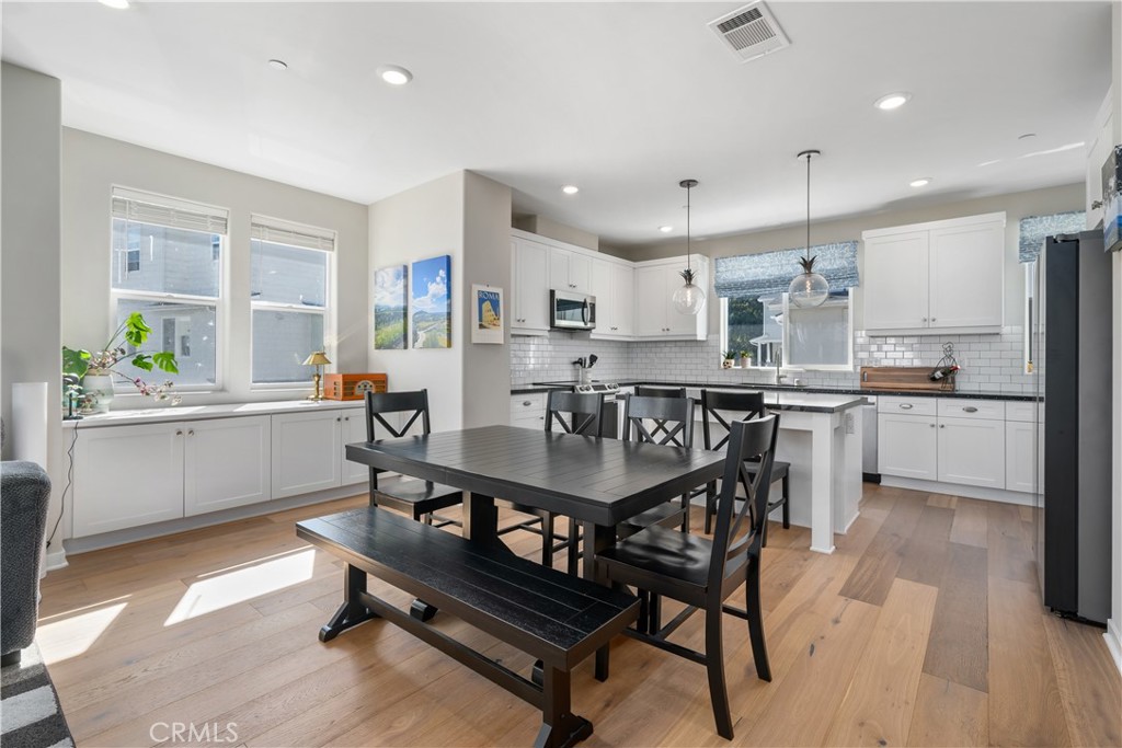 905 Madonna Road, Unit 69 San Luis Obispo, CA 93405 - Photo 4 of 26 a kitchen with a table chairs wooden cabinets and stainless steel appliances