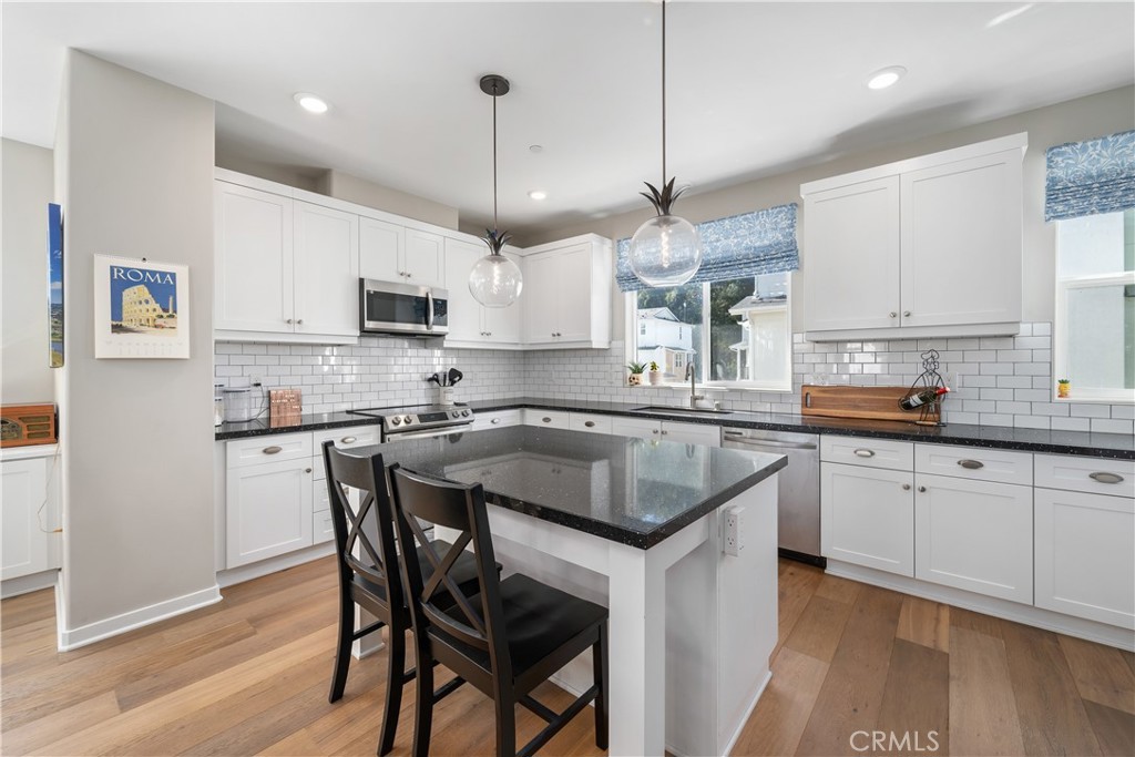 905 Madonna Road, Unit 69 San Luis Obispo, CA 93405 - Photo 8 of 26 a kitchen with stainless steel appliances granite countertop a stove a sink a microwave a refrigerator white cabinets and wooden floor