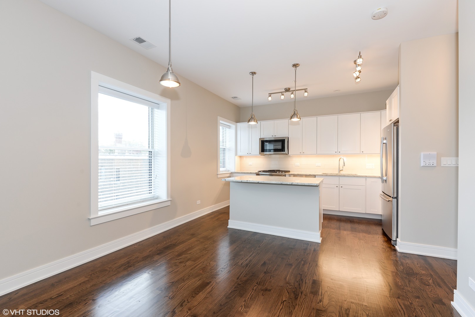 493 Sheridan Road, Unit 402 Evanston, IL 60202 - Photo 4 of 9 a large white kitchen with lots of counter space wooden floor and appliances