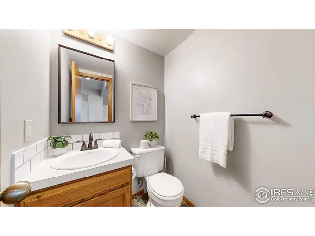a bathroom with a toilet sink vanity and mirror
