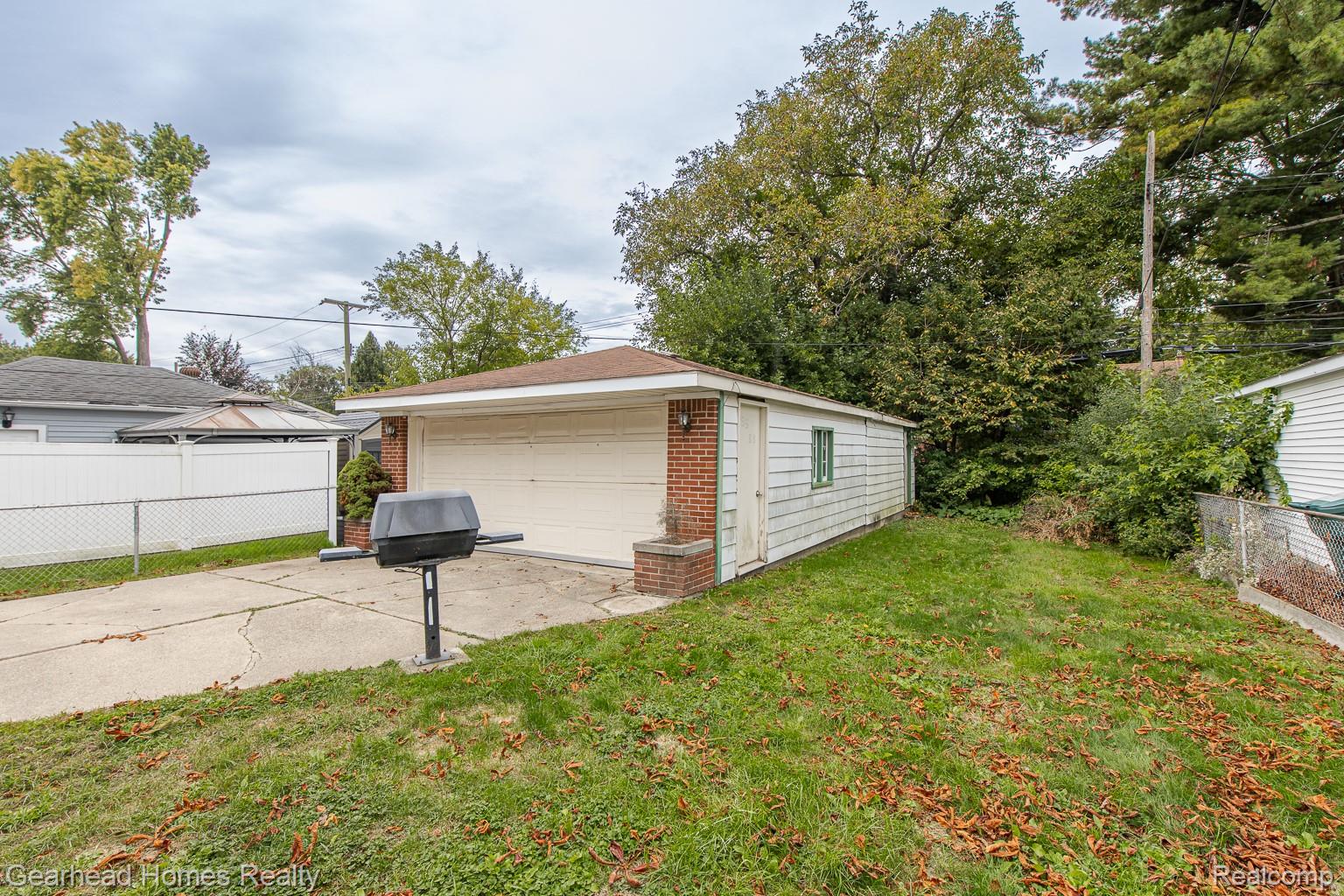 3356 Harding Street Dearborn, MI 48124 - Photo 37 of 48 Detached garage with a roll-up door, brick accents, and an extended concrete driveway