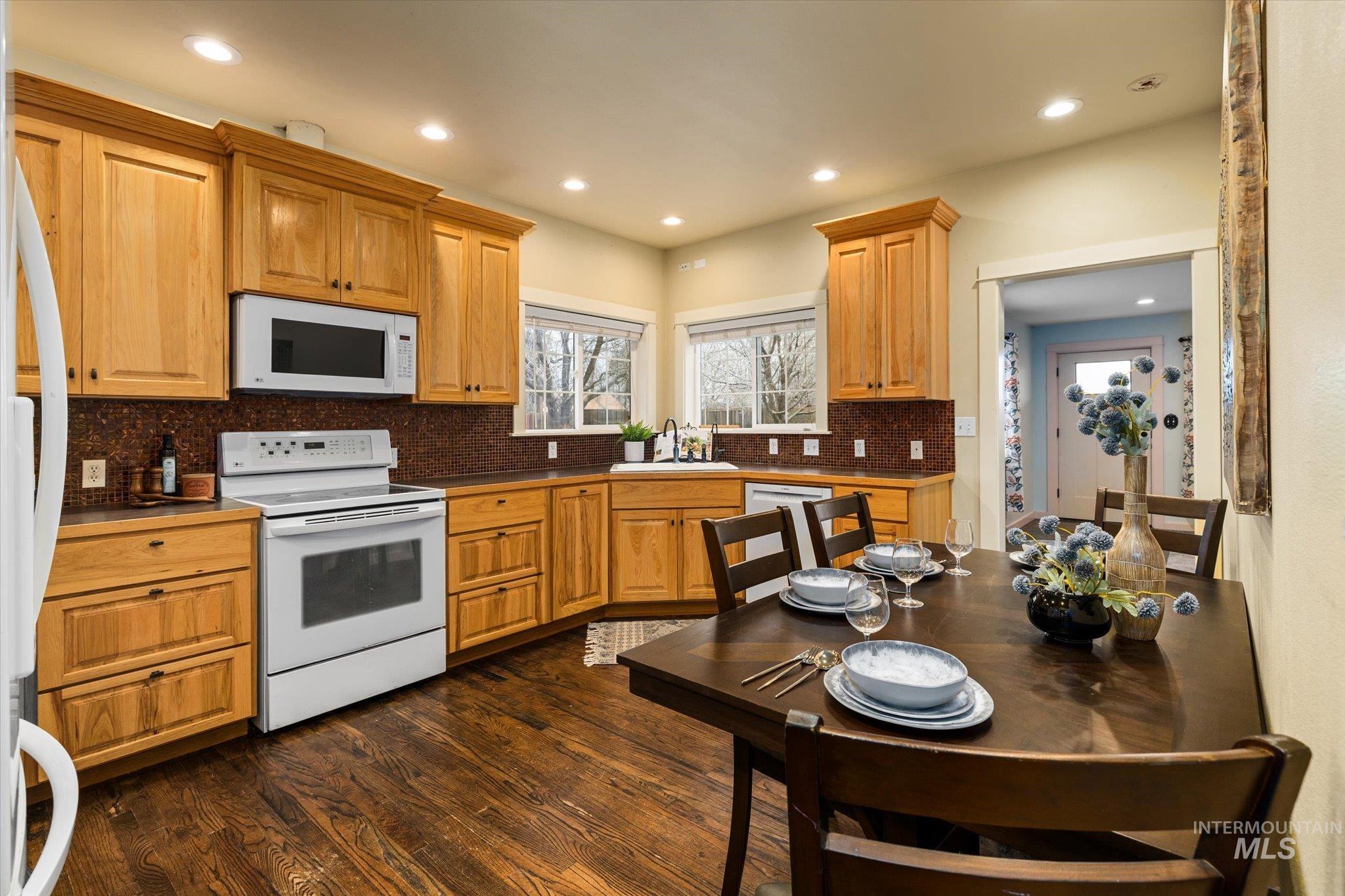 29410 Pearl Road Parma, ID 83660 - Photo 18 of 50 Kitchen with white appliances, dark wood-type flooring, decorative backsplash, recessed lighting, and brown cabinets
