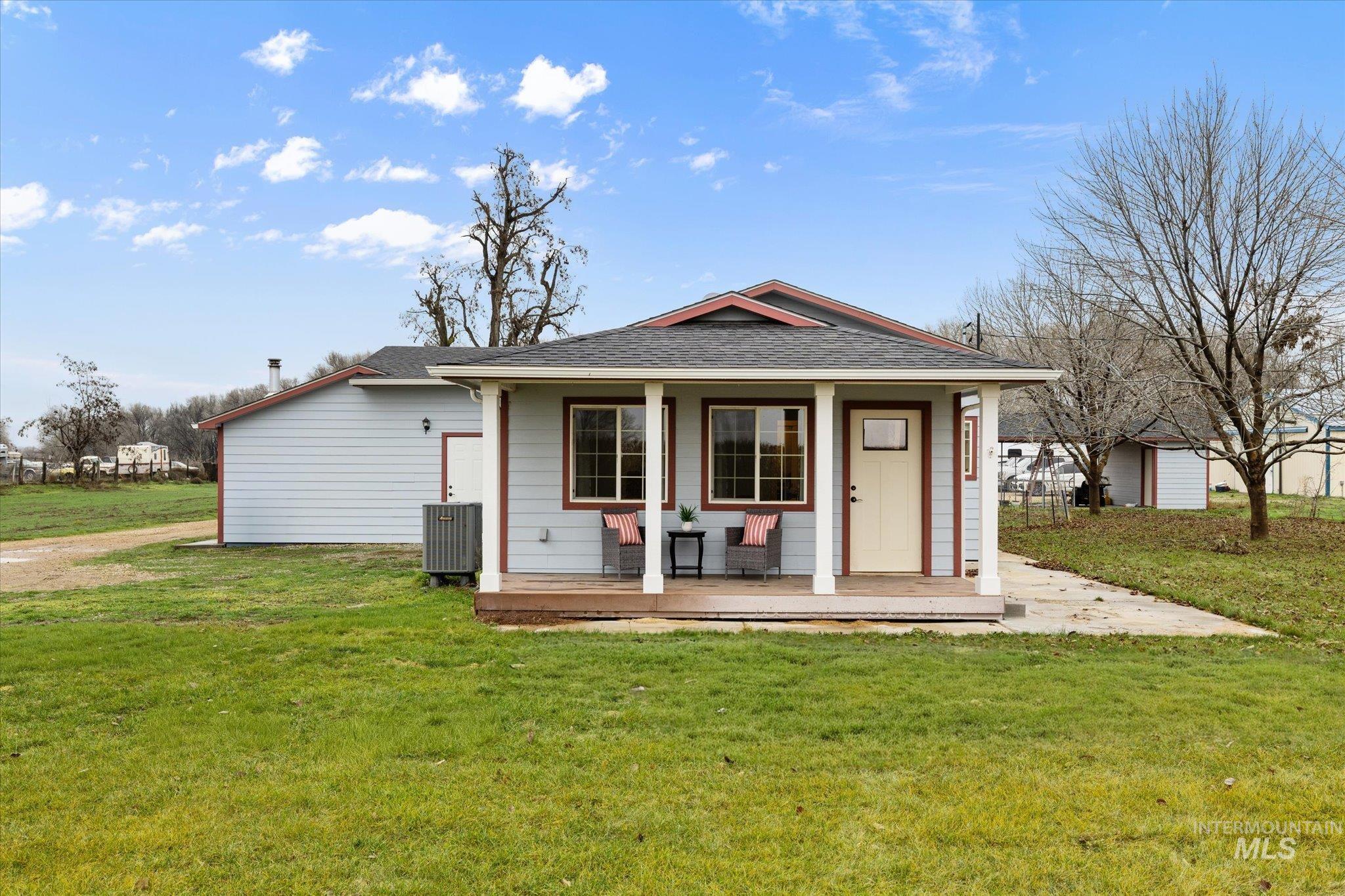 29410 Pearl Road Parma, ID 83660 - Photo 4 of 50 View of front facade featuring a front yard, a porch, roof with shingles, and an outdoor structure