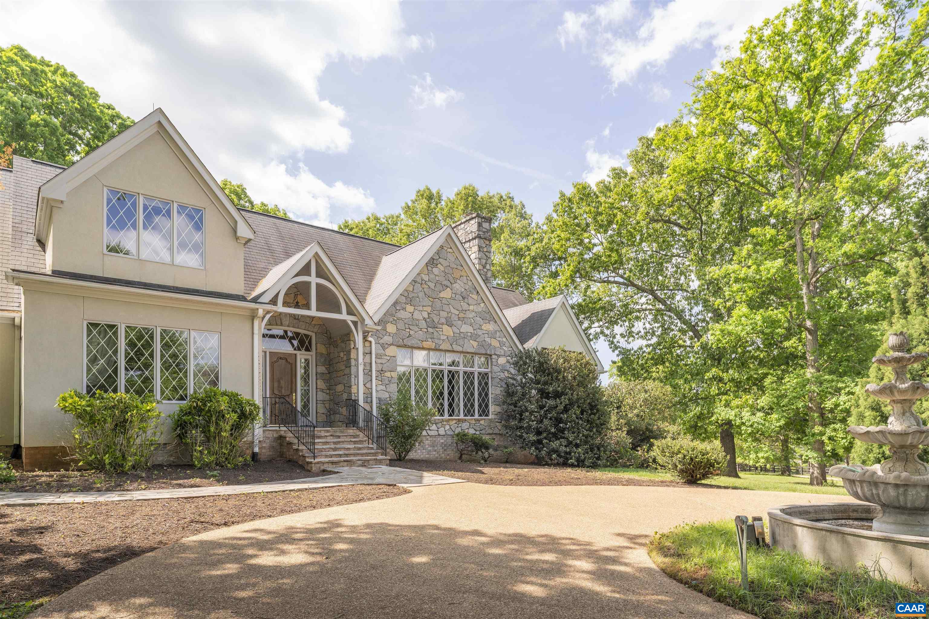 2121 Garth Road Charlottesville, VA 22901 - Photo 14 of 75 a view of a white house with a large tree and plants next to a road