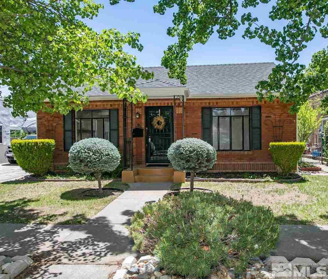 a view of a house with backyard and sitting area
