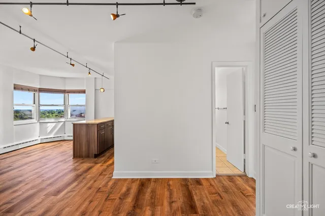 a view of a hallway with wooden floor and windows