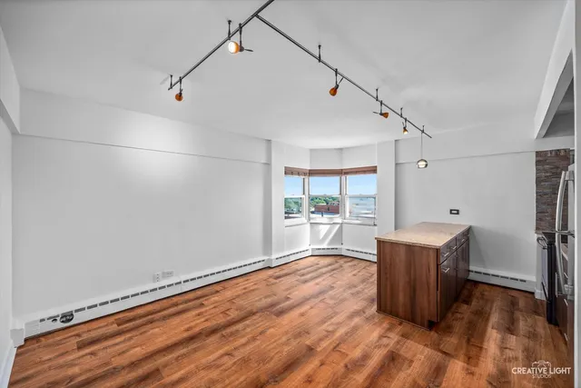 a room with wooden floor and stainless steel appliances