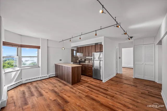 a view of a kitchen with a sink and a refrigerator