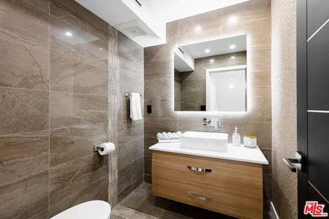 a bathroom with a sink a toilet and mirror