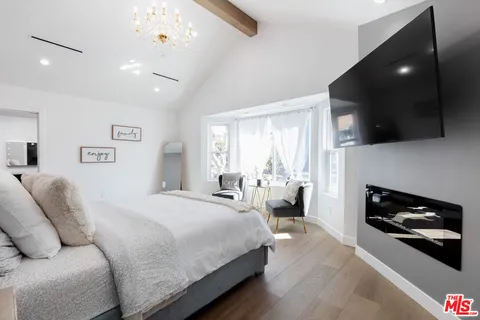 a spacious bedroom with a bed and a television