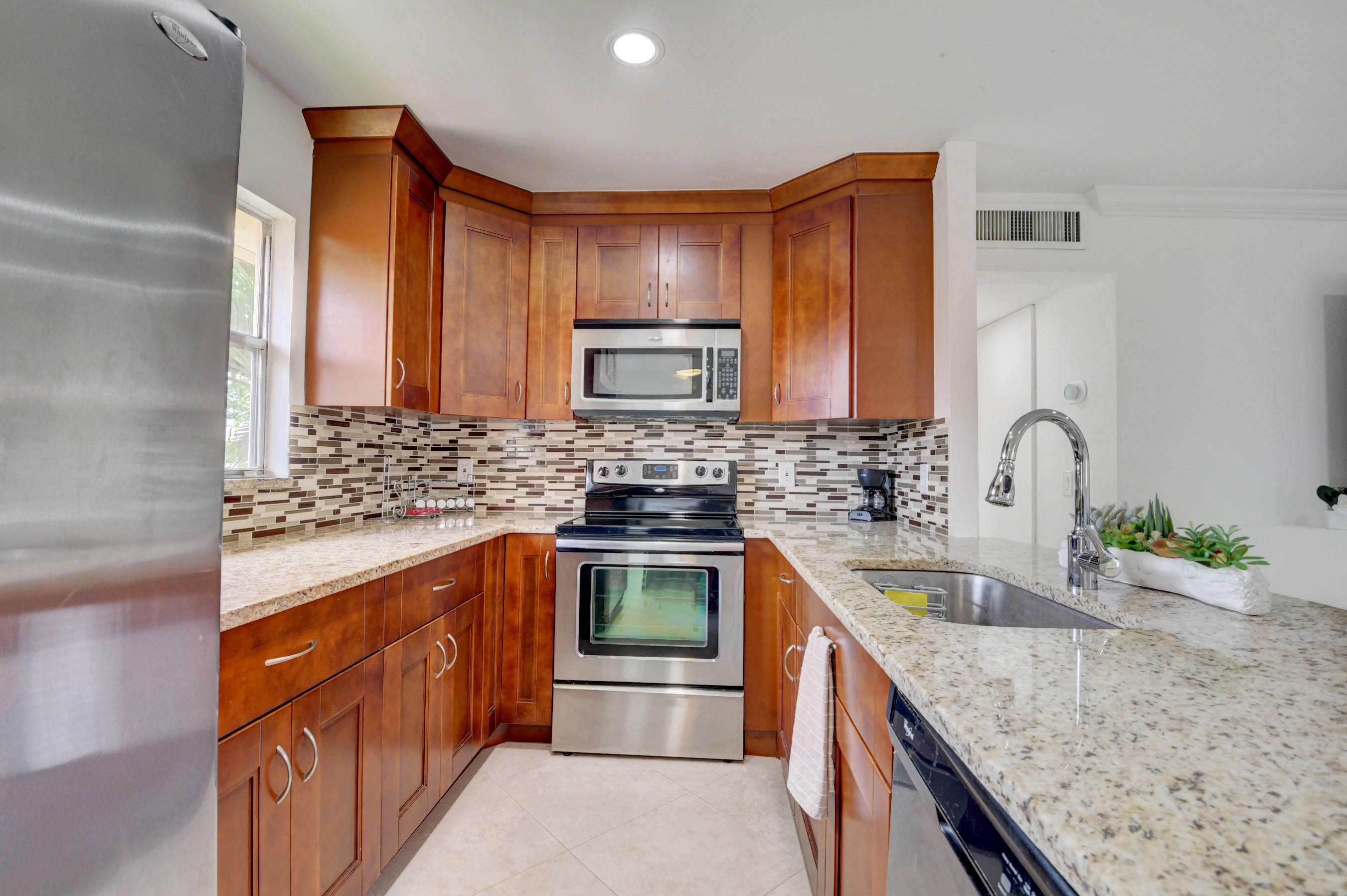 468 Saxony Way Delray Beach, FL 33446 - Photo 2 of 14 a kitchen with stainless steel appliances granite countertop a sink stove and cabinets