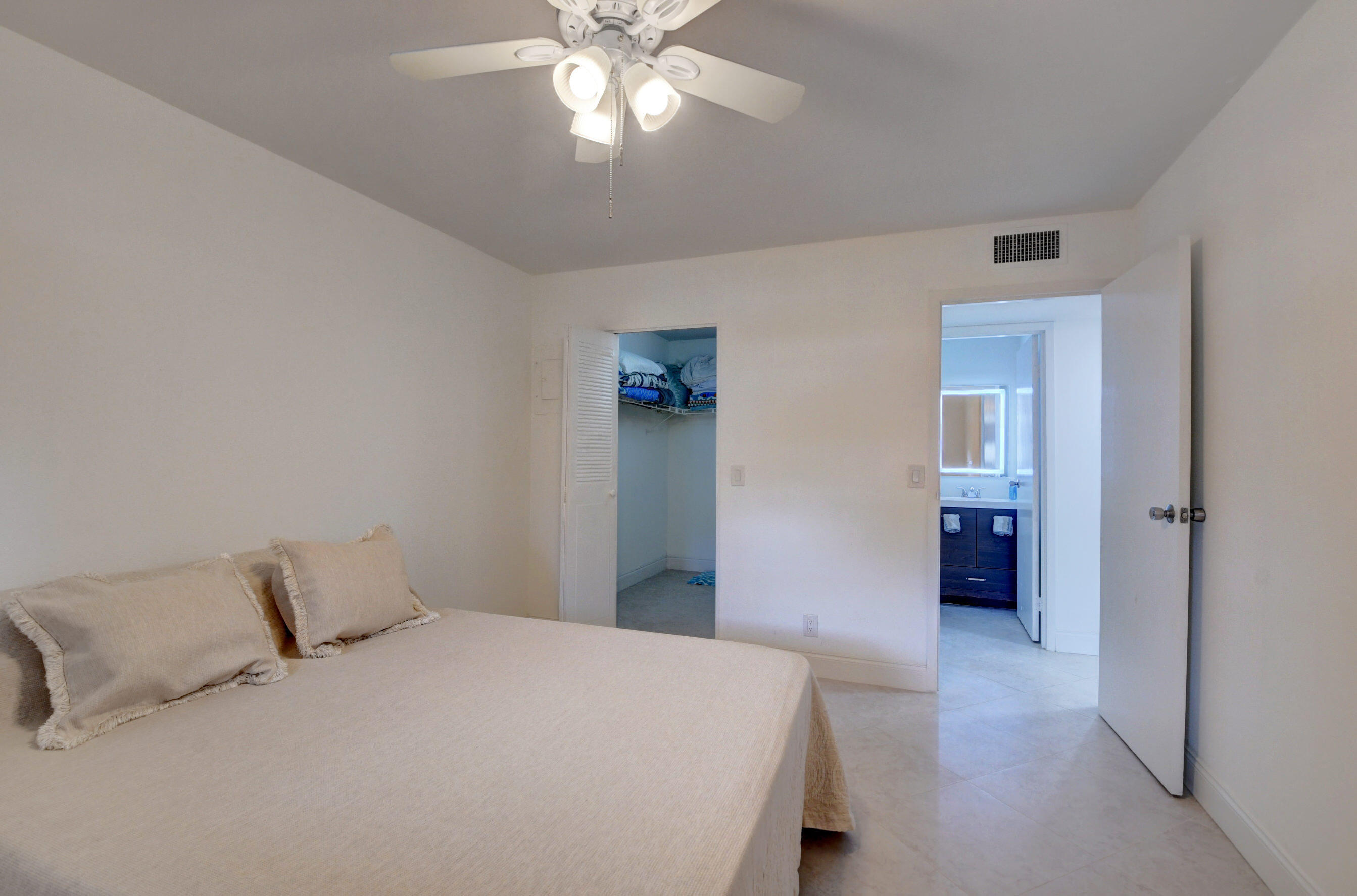 468 Saxony Way Delray Beach, FL 33446 - Photo 8 of 14 a bedroom with a large bed and a chandelier
