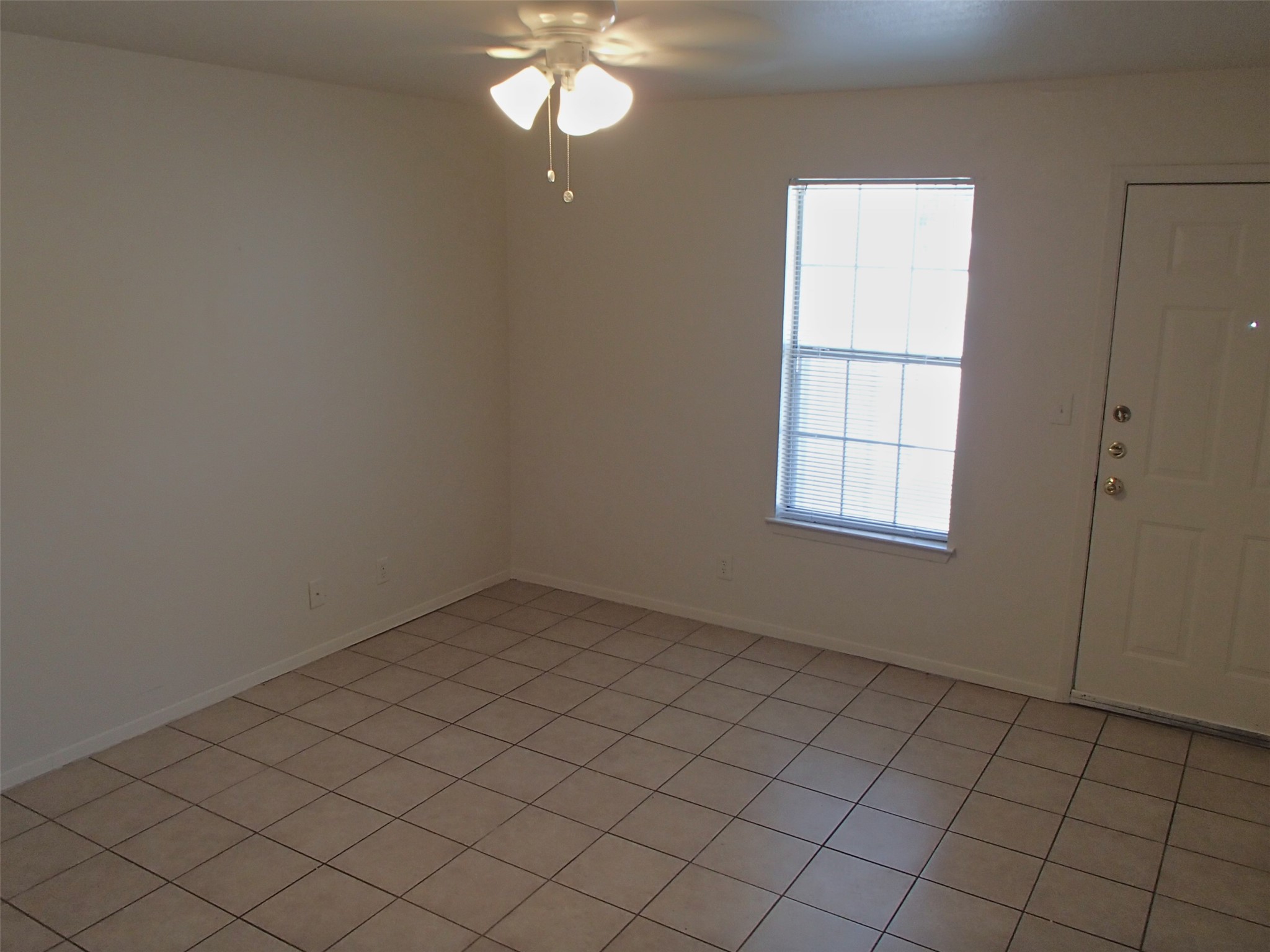 2202 Katy Lane, Unit A Georgetown, TX 78626 - Photo 5 of 9 Empty room with a ceiling fan and light tile patterned floors