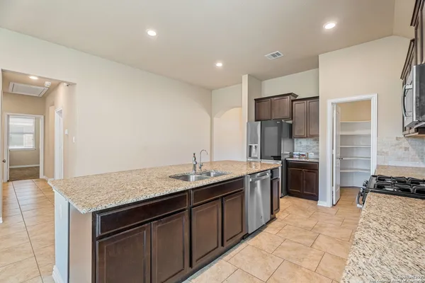 a kitchen with stainless steel appliances granite countertop a sink stove and refrigerator