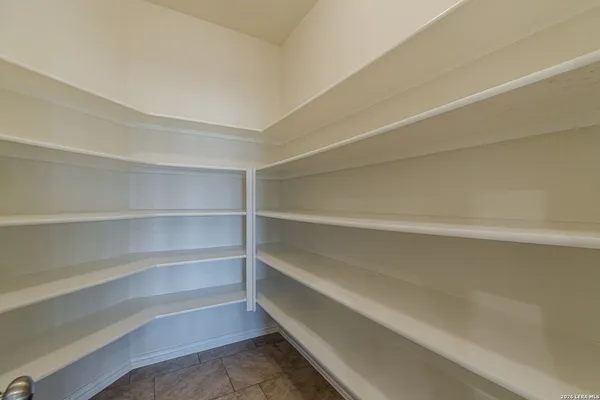 a view of walk in closet with empty racks