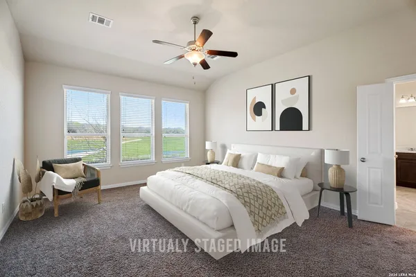 a spacious bedroom with a bed and glass window