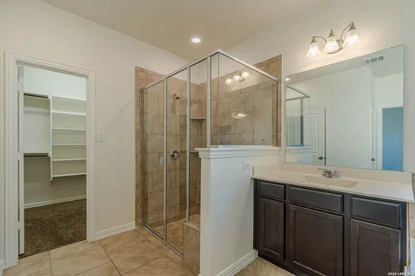 a bathroom with a shower sink and mirror